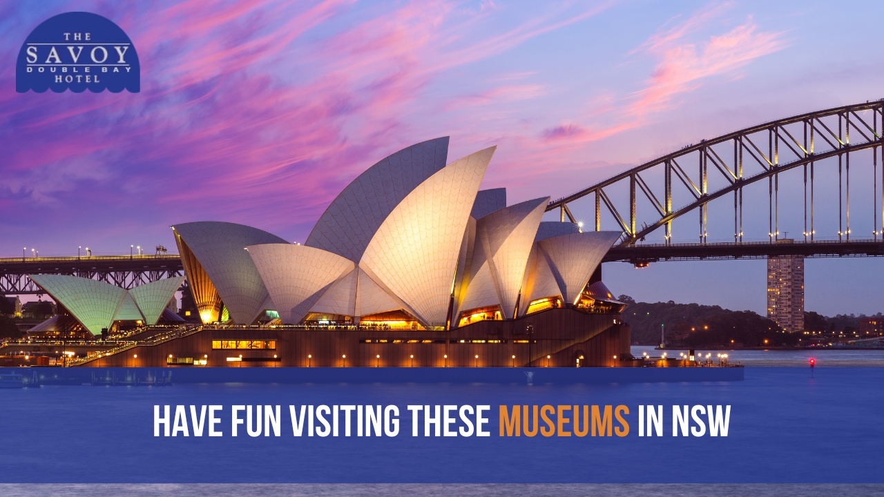 A sunset view of the lit-up Sydney Opera House and Sydney Harbour Bridge against a vibrant pink and purple sky.