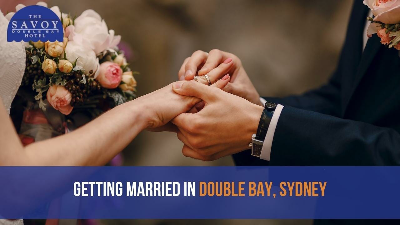 A groom placing a wedding ring onto the bride's finger during a ceremony.